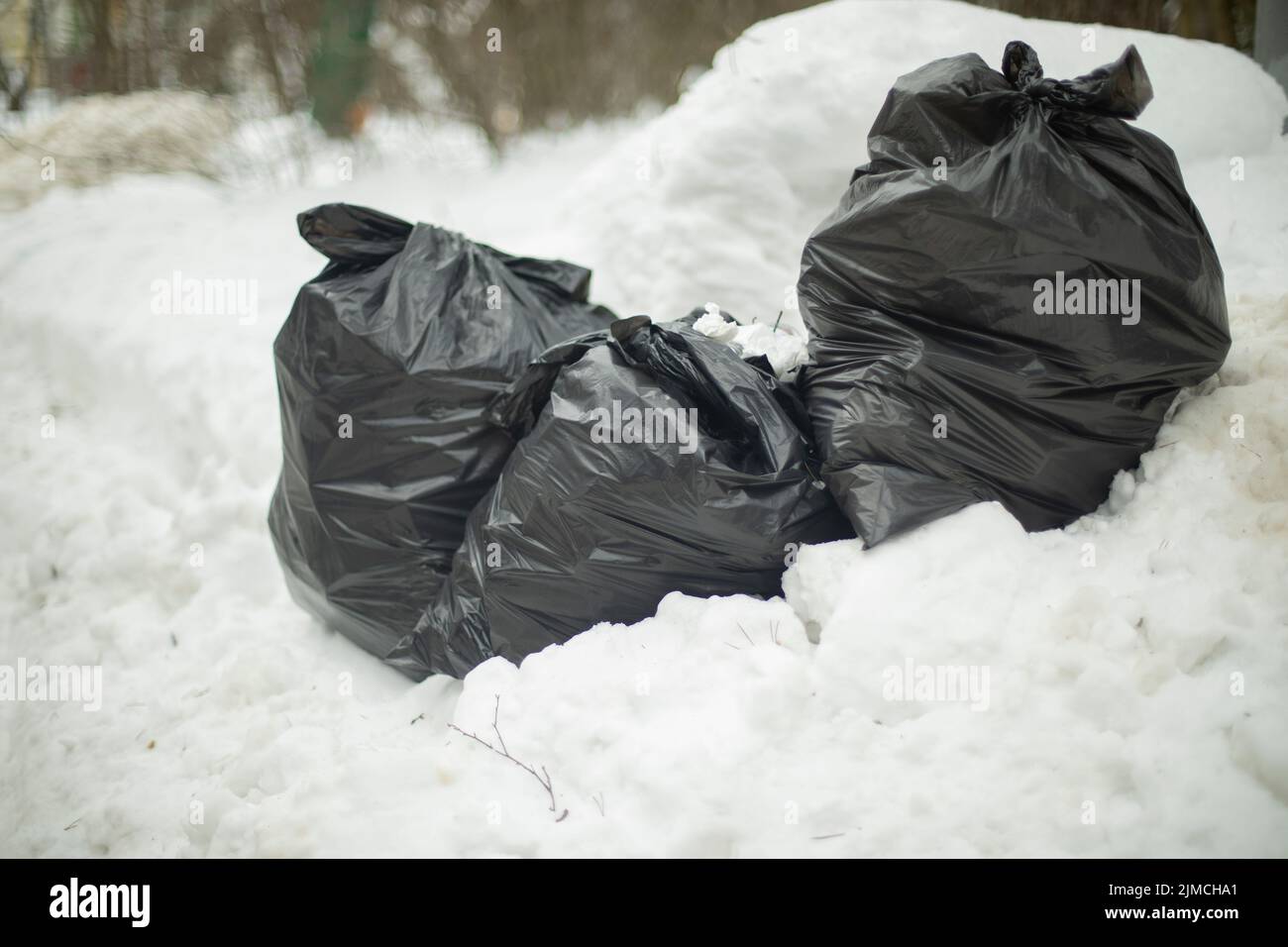 borse-nere-nella-neve-spazzatura-su-strada-rifiuti-in-sacchi-buttare-fuori-spazzatura-su-strada-discarica-illegale-2jmcha1